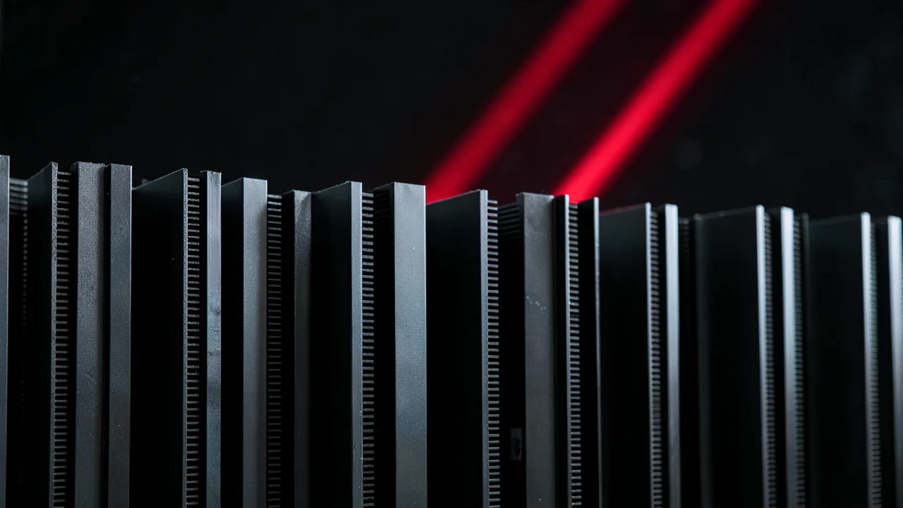 Filas de módulos de memoria DDR5 con disipadores negros y un trazo de luz roja ascendente que simboliza la subida de precios de 2026