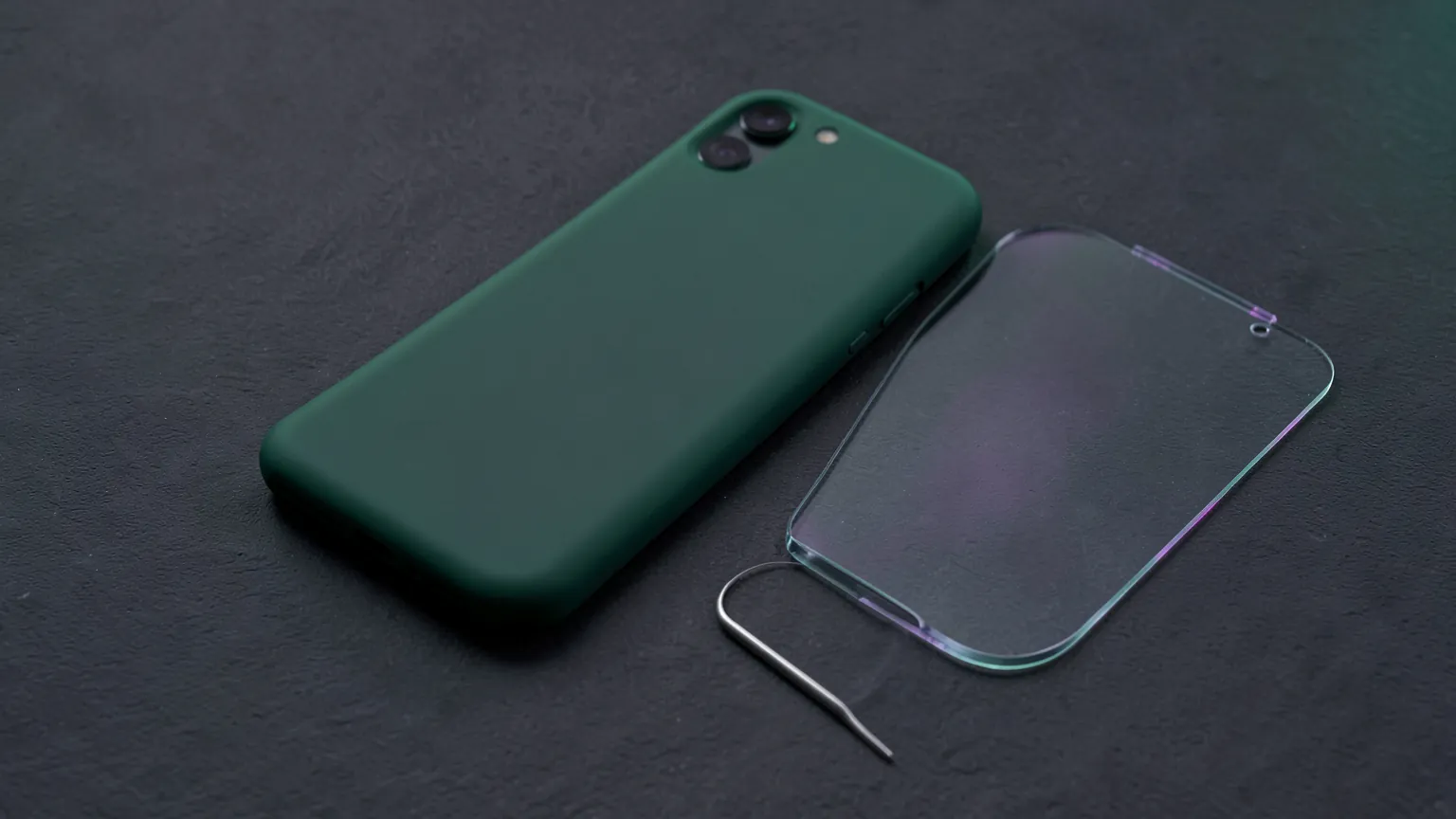 Teléfono moderno con funda sobre un escritorio oscuro junto a varios protectores y accesorios magnéticos